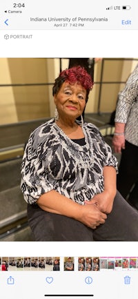 a woman is smiling in front of a group of people