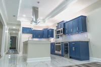 a kitchen with blue cabinets and marble counter tops