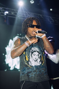 a man with dreadlocks singing into a microphone