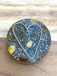 a heart shaped copper heart on a wooden table