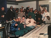 a group of people posing for a picture in a recording studio