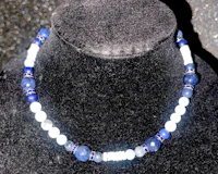 a necklace with blue and white beads on a mannequin