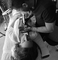 black and white photo of a man getting a tattoo