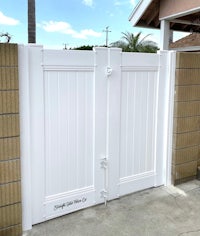 a white gate in front of a house in california