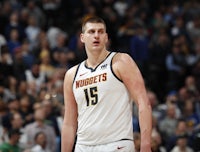 the denver nuggets player is standing on the court