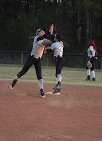 a softball player is trying to catch a ball