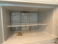 the inside of a refrigerator with dirty shelves