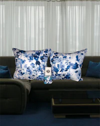 a living room with blue and white pillows and a bottle of wine