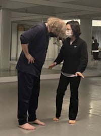 a man and a woman standing in a dance studio