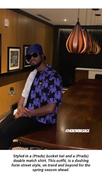 a man sitting at a table wearing a hat and sunglasses
