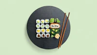 sushi on a plate with chopsticks on a green background