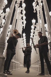 a group of musicians standing in a hallway with white lights