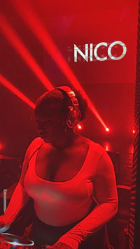 a woman is djing in front of a red light