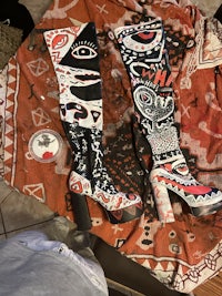 two pairs of thigh high boots on a rug
