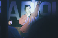 a man is holding a microphone in front of a crowd