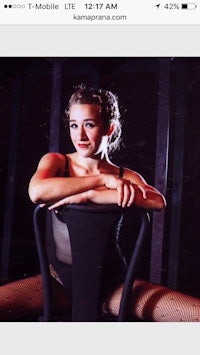 a woman sitting on a chair in a fishnet dress