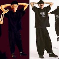 a man is posing in a black shirt and black pants