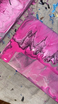 a pink and black painting on a table