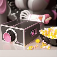 a movie projector with a bowl of popcorn next to it