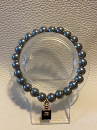 a bracelet with grey pearls on a white surface