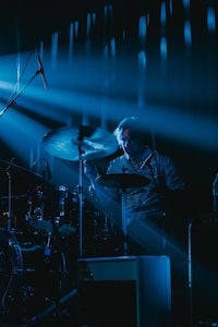 a man playing drums in a dark room