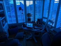a room with a desk, a chair, and a laptop