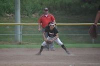 a softball player is preparing to catch a ball