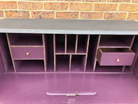 a purple desk with drawers and drawers