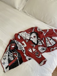 a red and white blanket laying on a bed