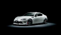 the white toyota 86 is shown in a dark room