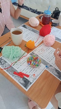 a group of women are knitting at a table