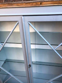 a white glass display cabinet with glass doors
