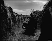 a black and white photo of a man standing in a field