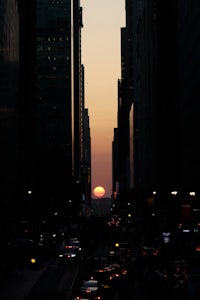 the sun is setting over a city street