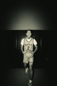 a black and white photo of a basketball player holding a ball