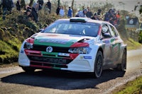 a volkswagen rally car driving down a country road