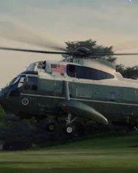 a white house helicopter is flying over a field
