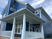 a blue house with white trim and porch