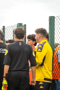 a group of people standing near a fence