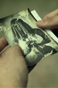 a person holding a photo of a woman with dreadlocks