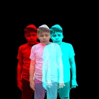 three boys standing next to each other in front of a black background