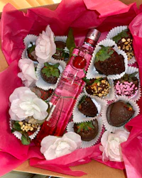a pink box filled with chocolates and a bottle of gin