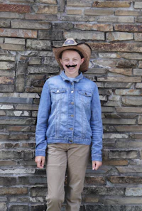 a girl wearing a cowboy hat and denim jacket