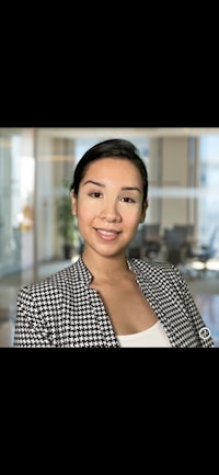 a woman in a blazer is smiling in an office