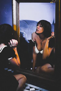 a woman looking at herself in a mirror