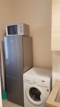 a small kitchen with a washing machine and refrigerator