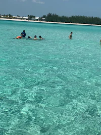 a group of people swimming in the clear blue water