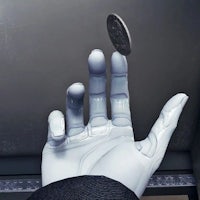 a robotic hand is holding a coin