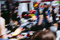 a person taking a picture of a red bull racing car