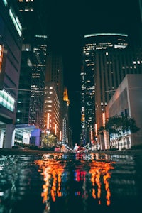 a city at night with a puddle of water